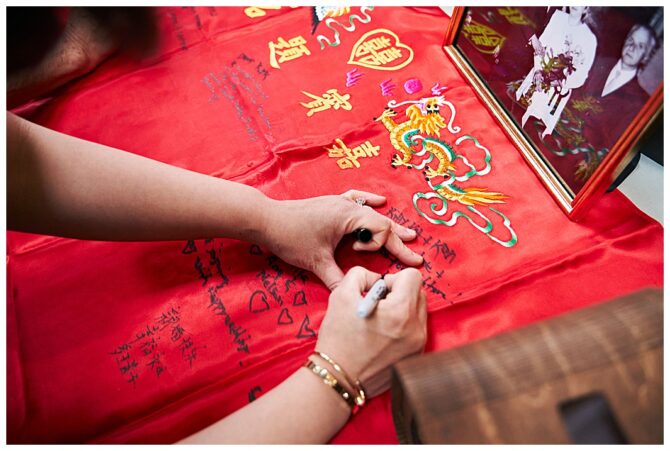 Person writing on red cloth with decorations