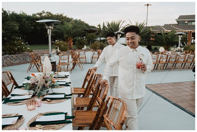 Wedding guests smiling and holding drinks outside.