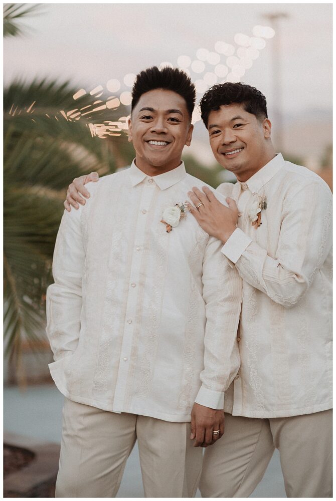 Two men smiling in traditional attire outdoors.