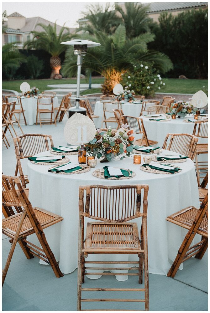 Outdoor wedding reception with decorated tables and chairs.