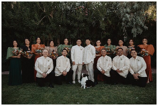 Formal group photo with diverse attire and dog.