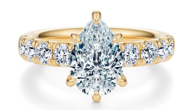 Gold ring with pear-cut diamond centerpiece.